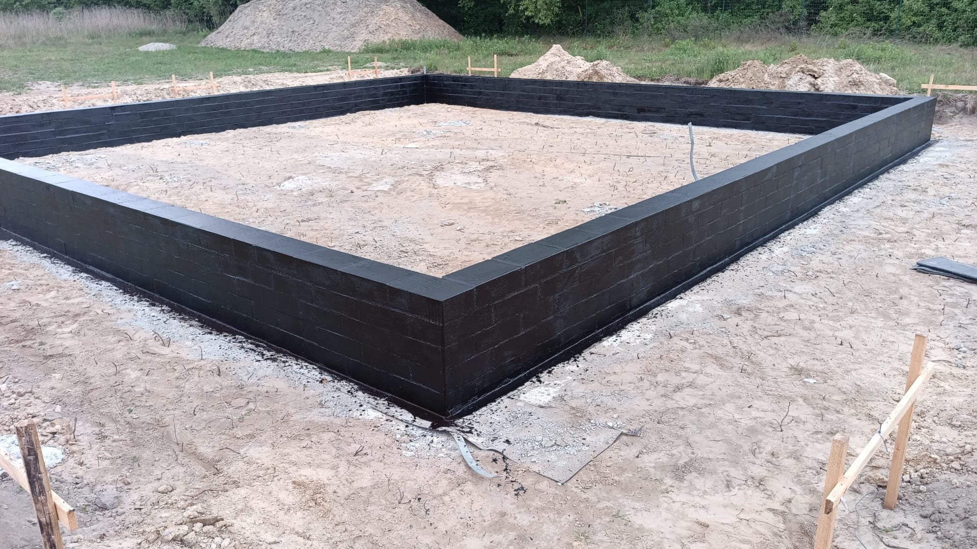 Ściany fundamentowe z wykonaną hydroizolacją na budowie domu